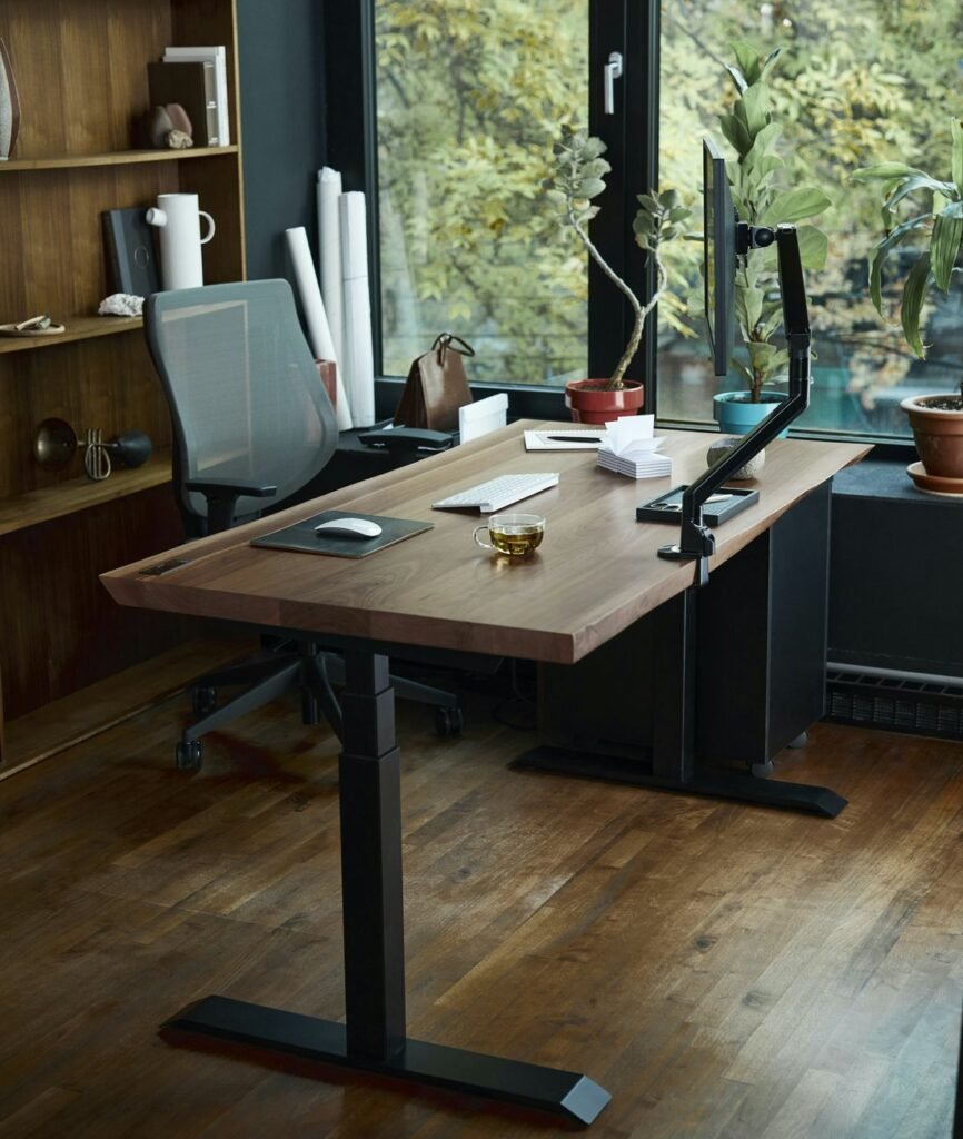 Wooden standing desk with a monitor and keyboard in a bright home office