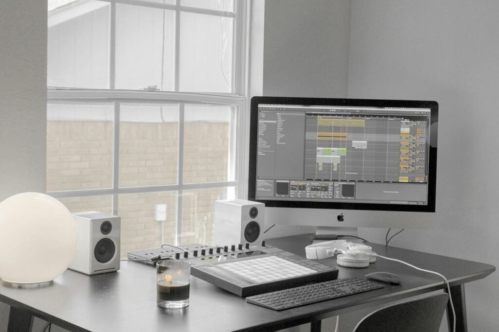 Compact desk by a window with a small monitor and laptop
