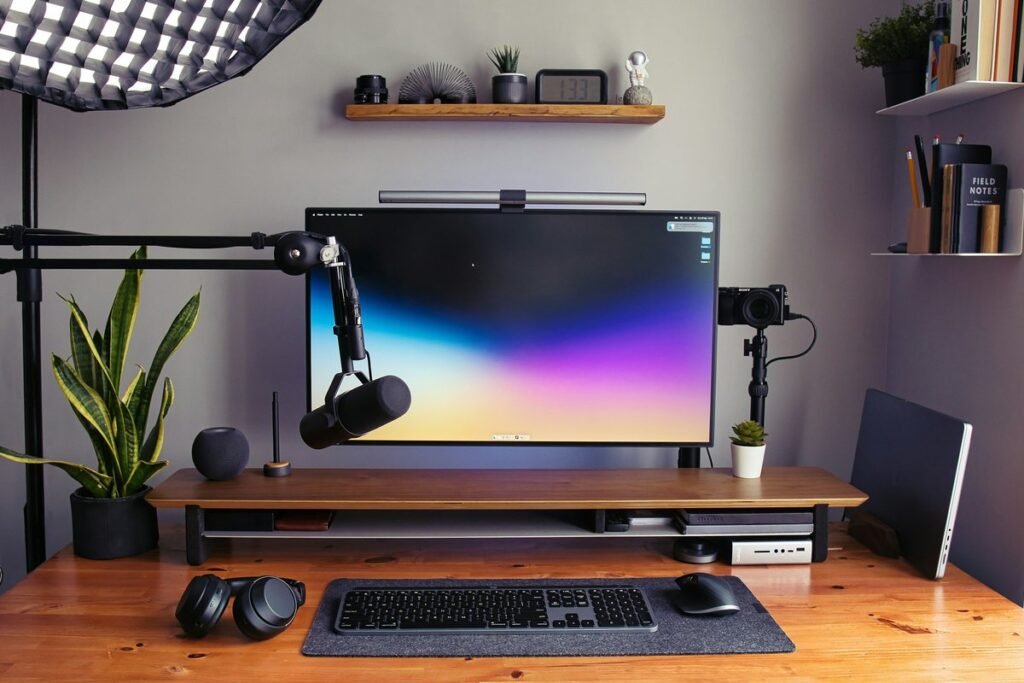 Creator desk with a monitor, microphone on a boom arm, and shelves